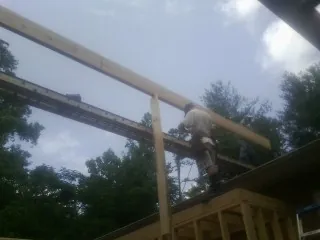 Carpenter setting a ridge beam over a new addition frame — Ice Dam Removal by Roofing Brothers in Guerneville
