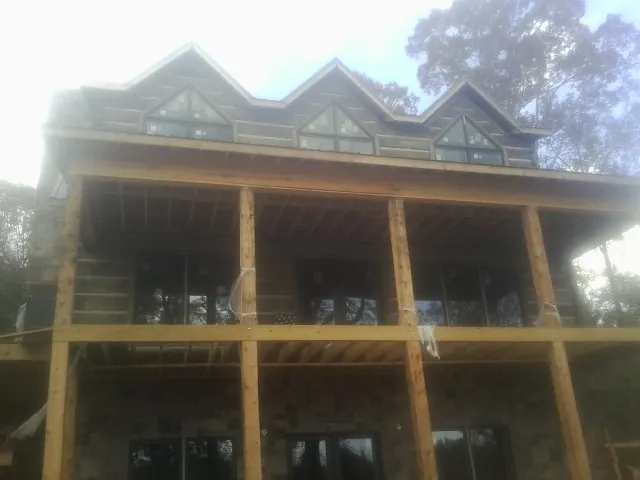 Dormers and porch framing on a large log home under construction — Roof Coating work by our crew in Guerneville